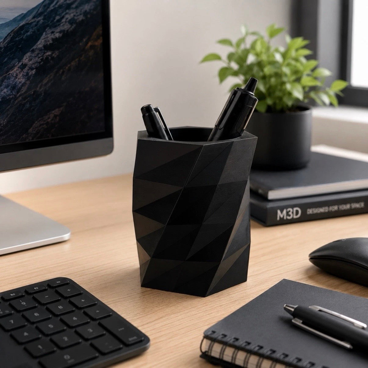 Black geometric pen holder on a desk with a computer, keyboard, mouse, and notebook.