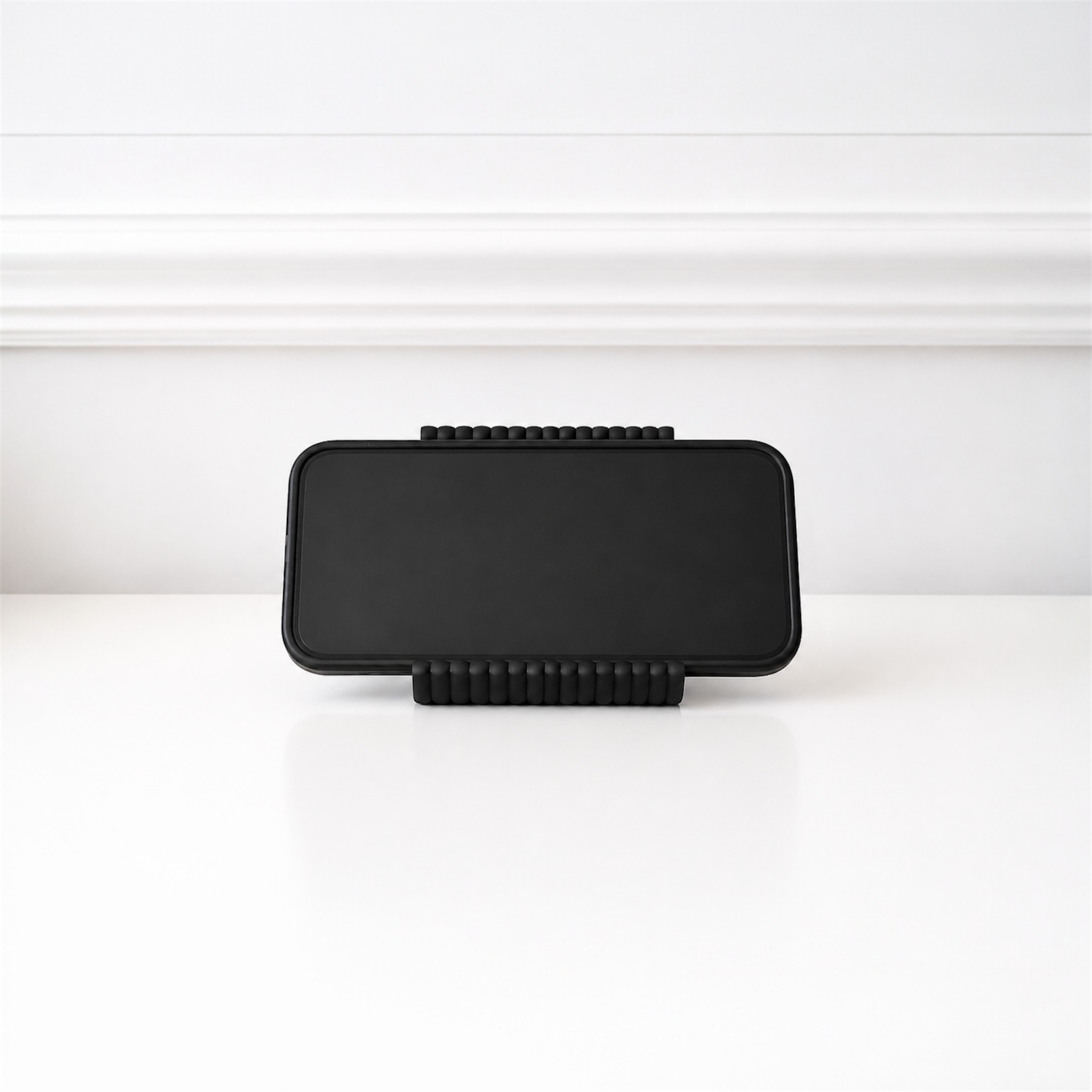 Black rectangular object with textured edges on a white background